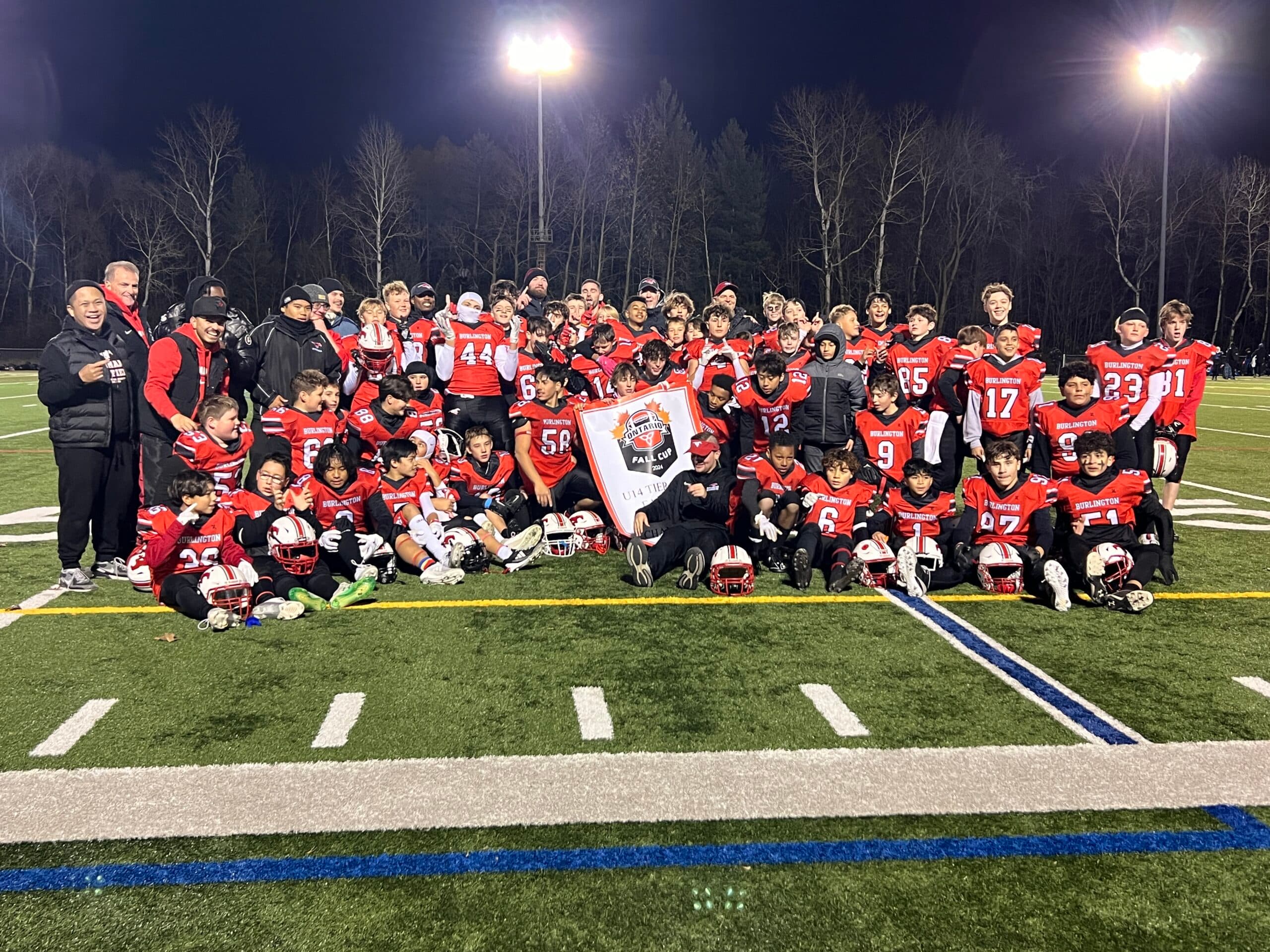 Burlington Stampeders U14 football team group photo on an outdoor field at night during the 2024 season.